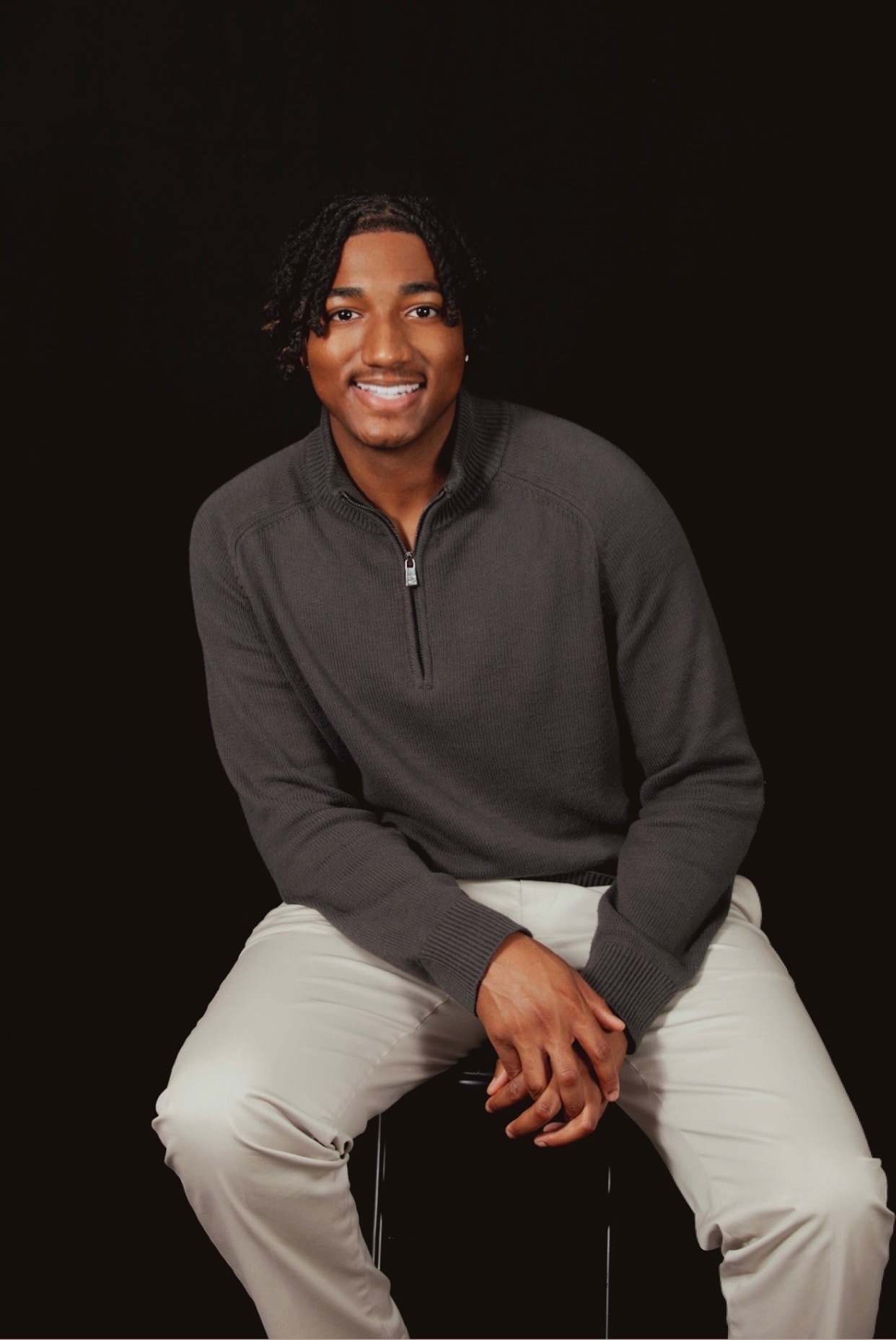 Tyrell James II smiling in a charcoal sweater