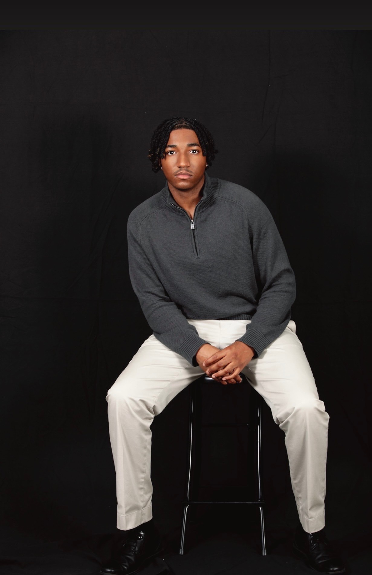 Tyrell James II seated in a charcoal sweater